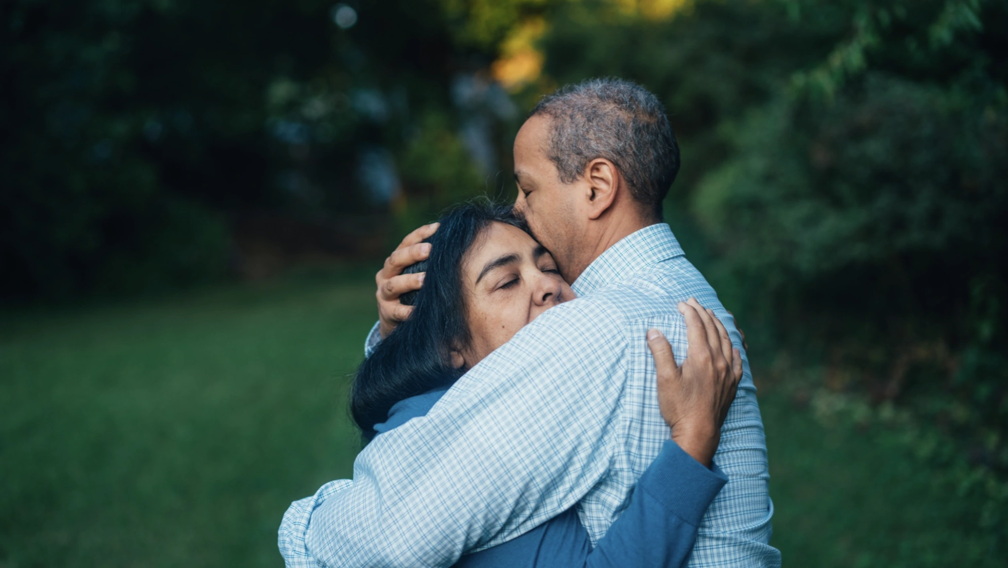 Two people embracing outdoors.