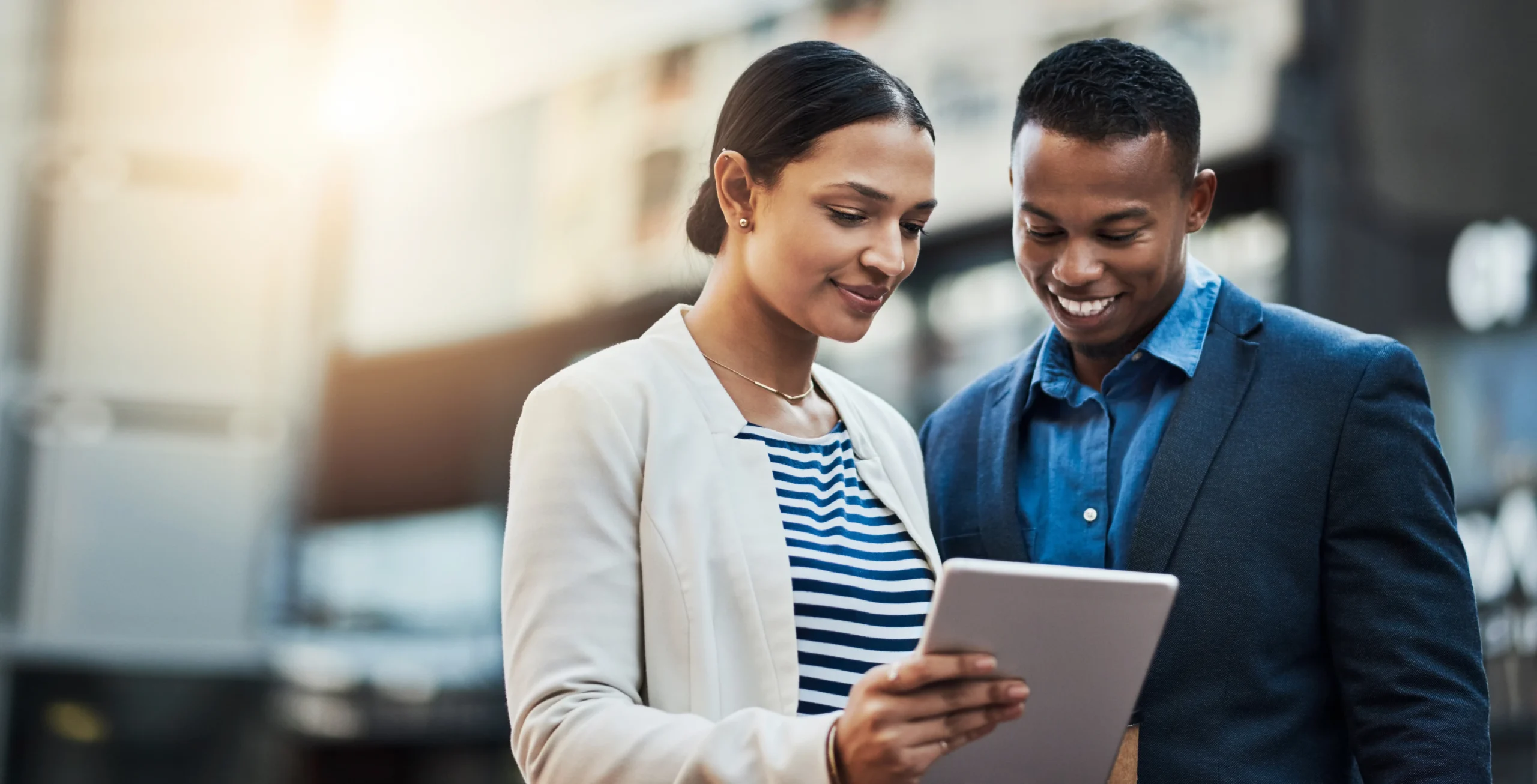 Two people working together with a tablet.